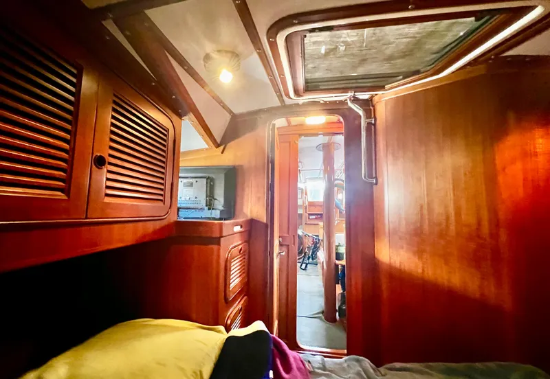 Interior of 1987 Norseman 400 sailboat with wooden cabinetry and cozy lighting.