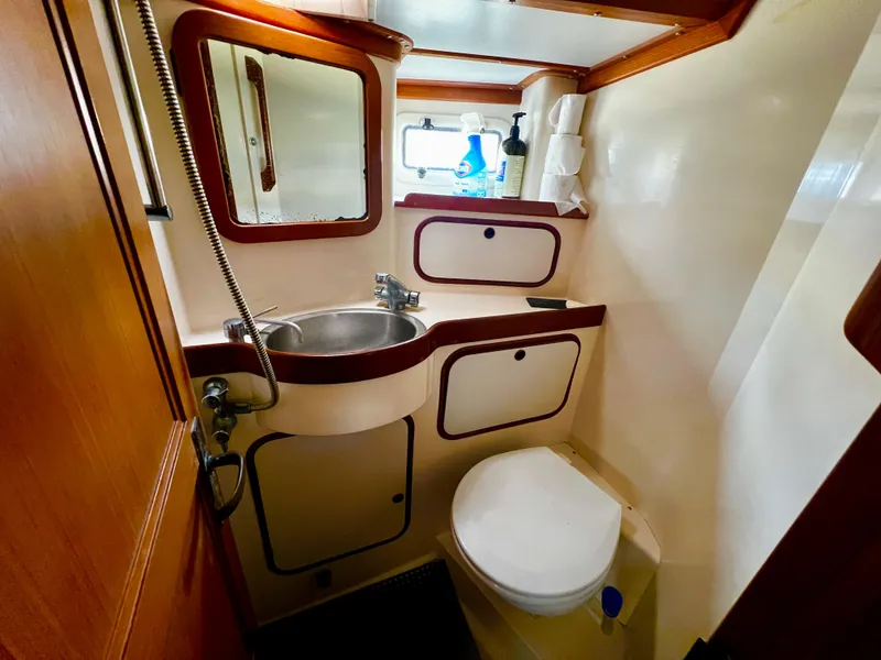 Compact bathroom in 1987 Norseman 400 yacht with sink, toilet, and mirror.