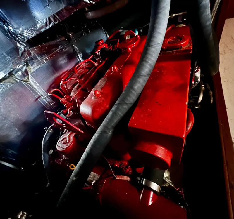 Red engine of a 1987 Norseman 400, featuring prominent hoses and metallic surroundings.
