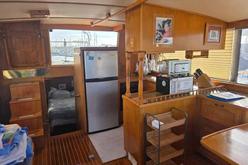 1983 Sea Ranger 45 Sun Deck interior with kitchen, bed, and wooden cabinetry.
