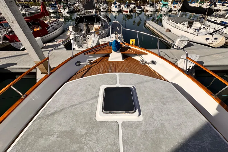 1983 Sea Ranger 45 Sun Deck yacht docked in a marina, surrounded by sailboats.