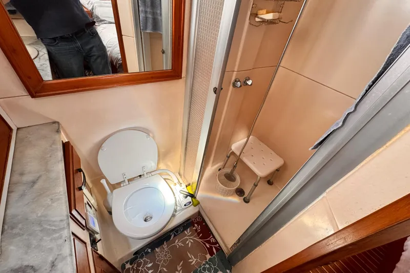 Compact bathroom in 1983 Sea Ranger 45 Sun Deck yacht with shower and toilet.