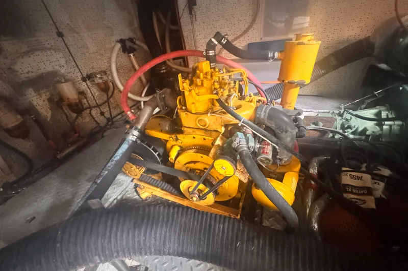 Engine room of 1983 Sea Ranger 45 Sun Deck with visible yellow machinery and hoses.