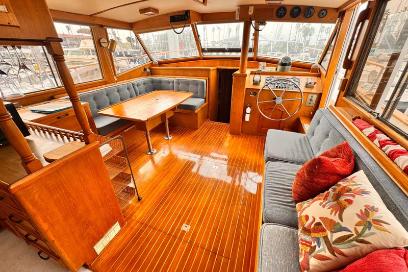 Interior of 1983 Sea Ranger 45 Sun Deck yacht with wooden flooring and cozy seating.