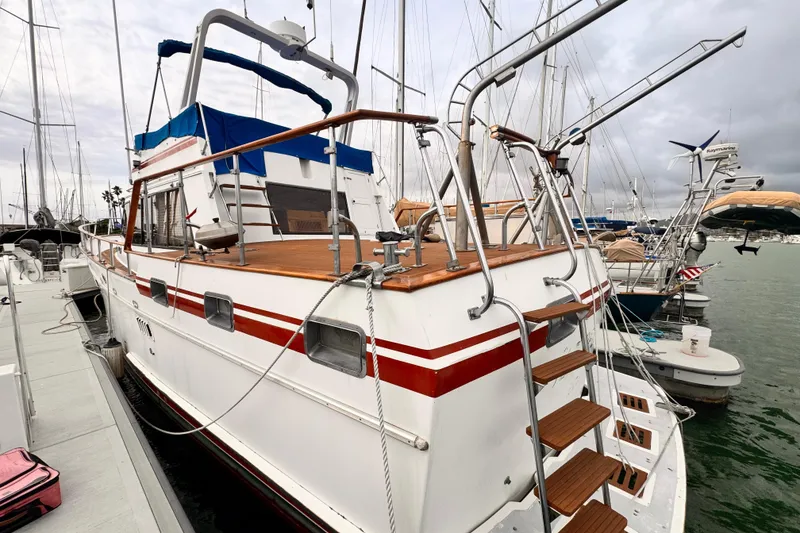 1983 Sea Ranger 45 Sun Deck yacht docked at marina, featuring wooden accents and blue canopy.