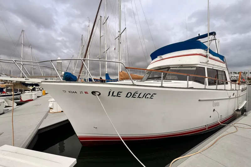 1983 Sea Ranger 45 Sun Deck yacht docked at marina under cloudy skies.