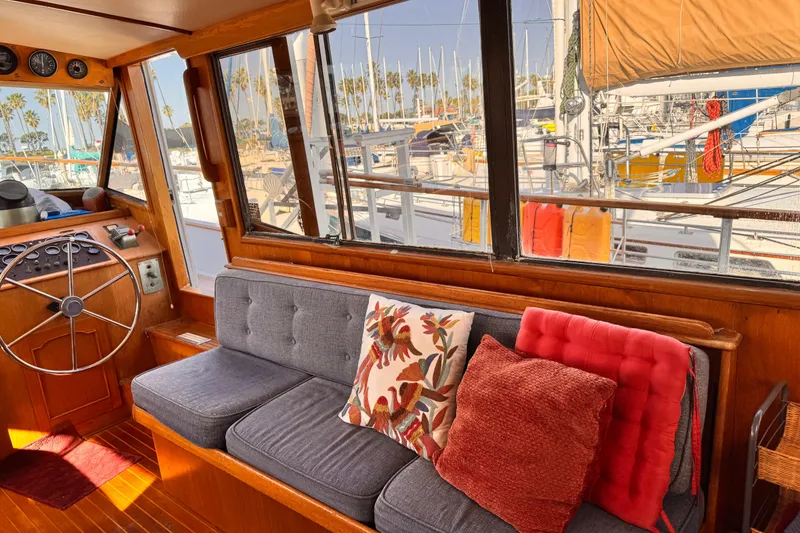 Interior of 1983 Sea Ranger 45 Sun Deck with cozy seating and marina view.