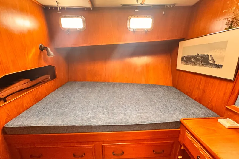 Cozy cabin interior of 1983 Sea Ranger 45 Sun Deck with wooden finish and blue mattress.