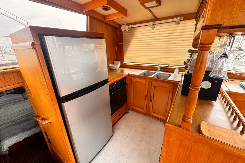 1983 Sea Ranger 45 Sun Deck kitchen with wooden cabinetry and modern appliances.
