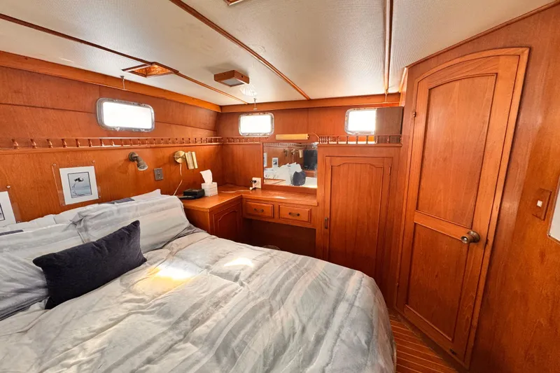 Cozy bedroom interior of 1983 Sea Ranger 45 Sun Deck yacht with wooden furnishings.