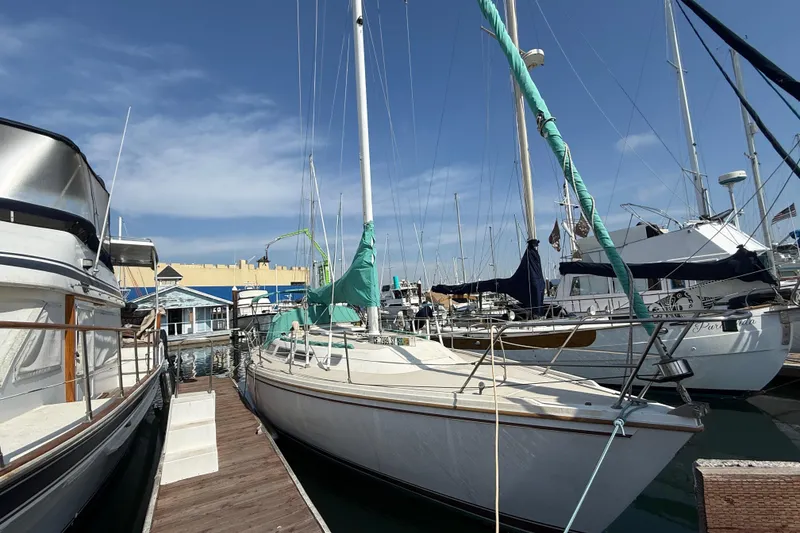 1987 Catalina 36 sailboat docked at marina under clear blue sky.