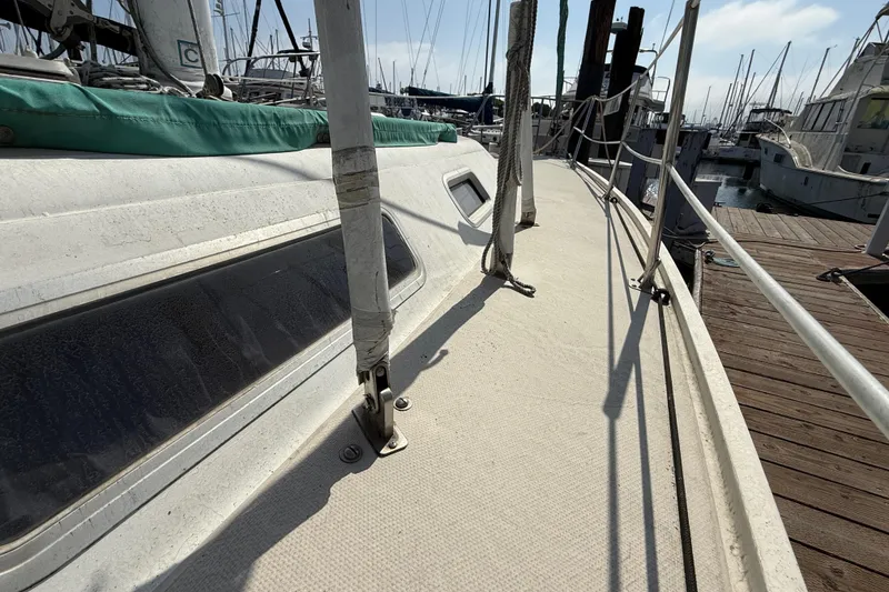 1987 Catalina 36 sailboat deck view at marina, showcasing rigging and dock.