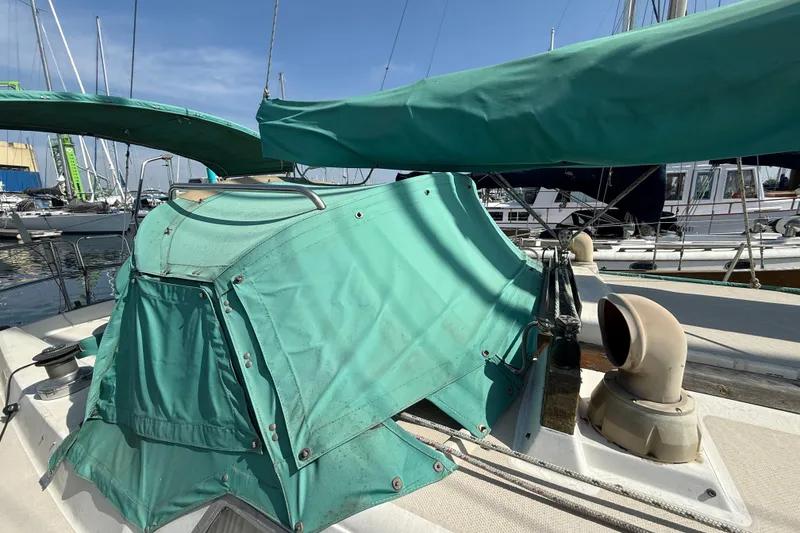1987 Catalina 36 sailboat with green canvas cover at marina.