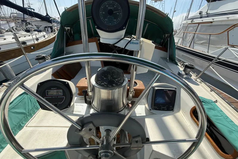 Cockpit view of a 1987 Catalina 36 sailboat with steering wheel and navigation instruments.