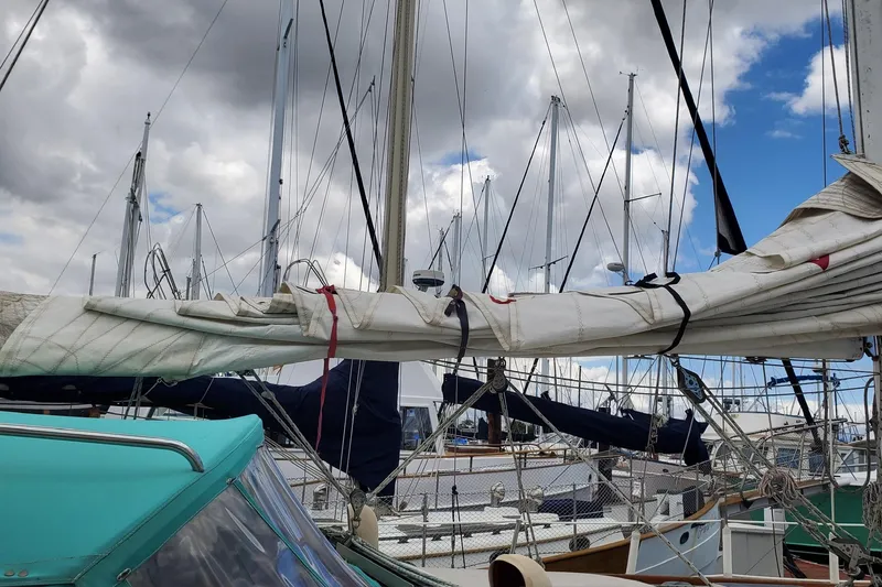1987 Catalina 36 sailboat with sails down, docked under cloudy sky.