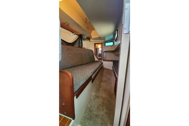 Interior cabin of a 1987 Catalina 36 sailboat with cushioned seating and storage.