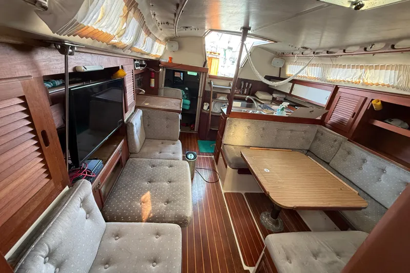 Interior of a 1987 Catalina 36 sailboat with cozy seating and wooden finishes.