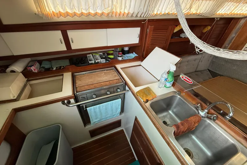 1987 Catalina 36 yacht kitchen with stove, sink, and storage cabinets.