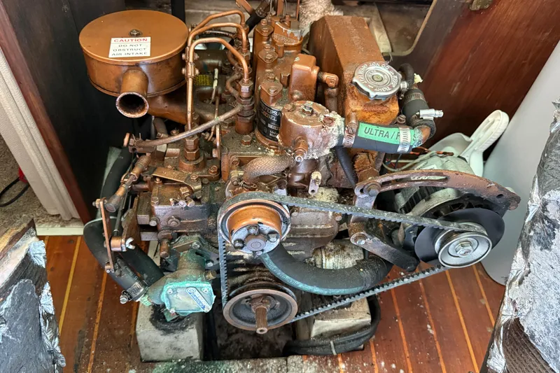 Rusty engine of a 1987 Catalina 36 sailboat, showing belts and components.
