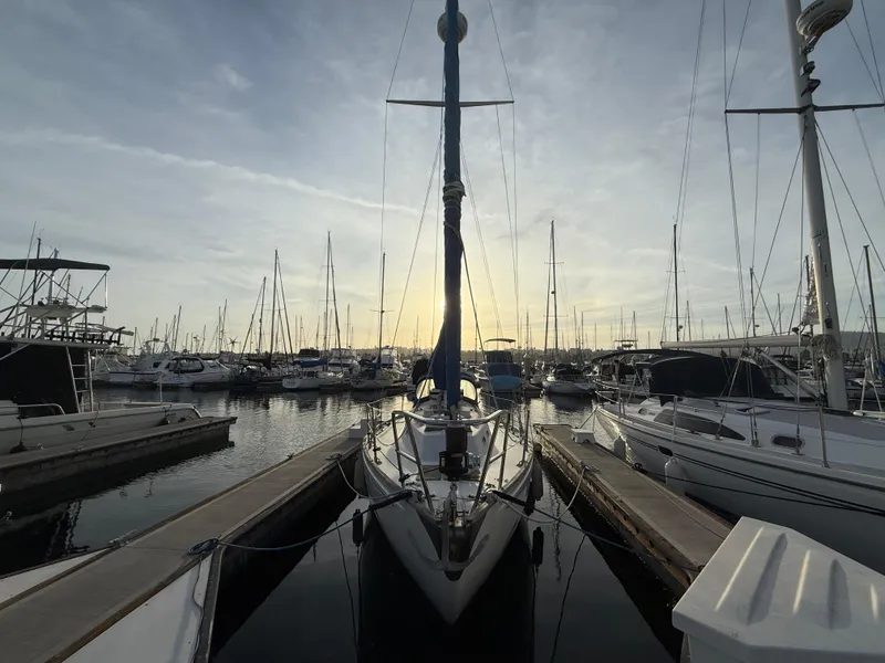 1980 Rival 32 sailboat docked at sunset in marina.