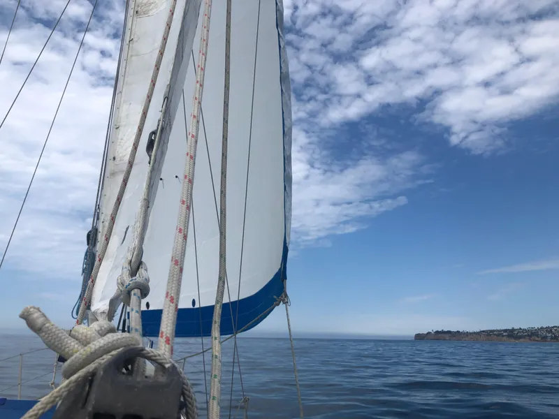 1980 Rival 32 sailboat on calm sea under blue sky.