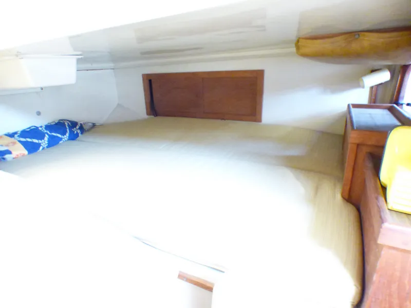 Cozy cabin interior of 1984 Catalina 36 Sloop with wooden accents and bedding.