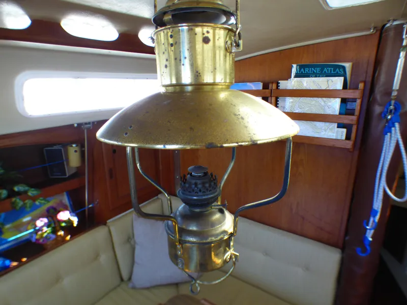 Vintage brass lamp inside 1984 Catalina 36 Sloop sailboat cabin, with nautical decor.