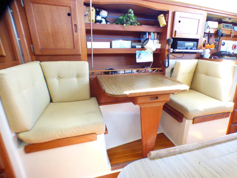 1984 Catalina 36 Sloop interior with cozy seating and wooden table.