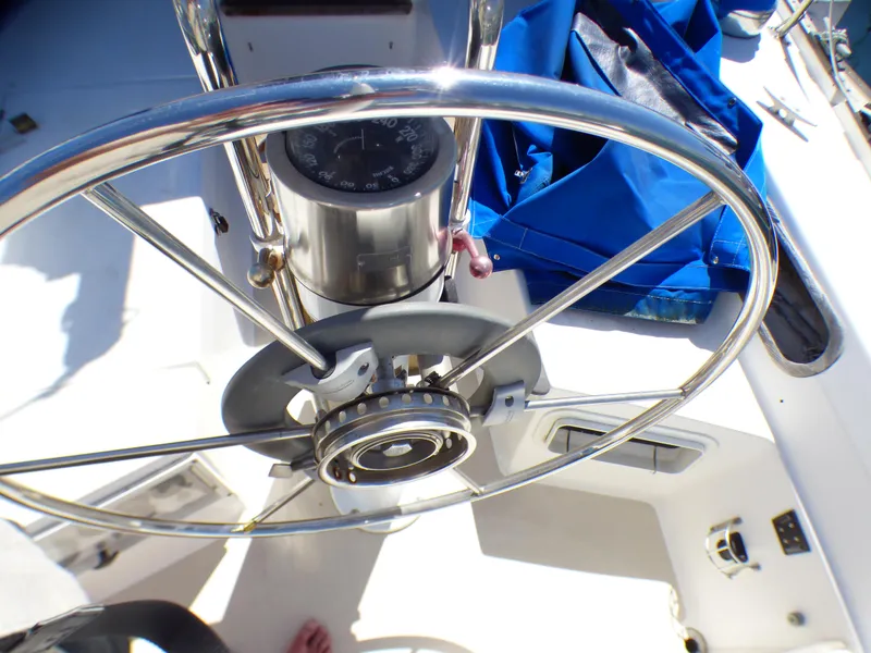 Steering wheel of a 1984 Catalina 36 Sloop sailboat with compass and blue cover.