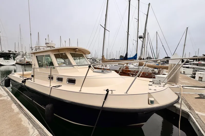 2003 Albin 28 TE boat docked in a marina, surrounded by sailboats.