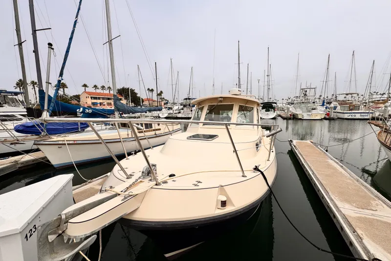 2003 Albin 28 TE boat docked in a marina with sailboats.