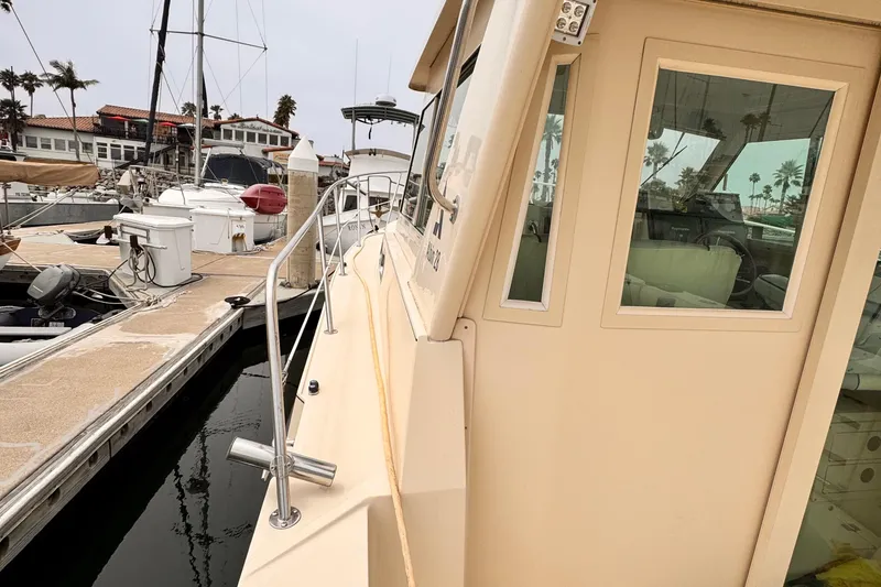 2003 Albin 28 TE docked at marina with palm trees in background.