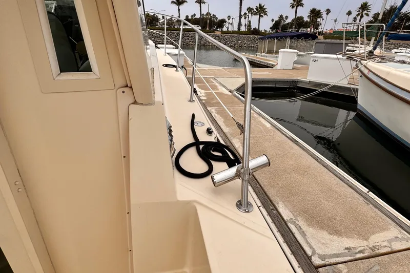 2003 Albin 28 TE boat docked at marina with palm trees in background.