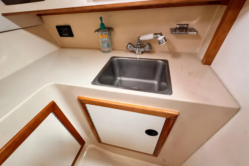 2003 Albin 28 TE boat interior with sink and storage cabinet.