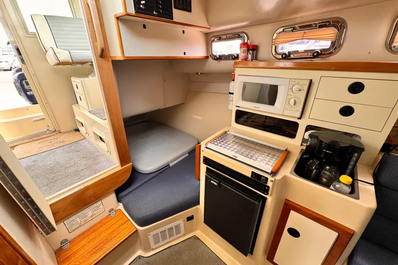 2003 Albin 28 TE cabin interior with kitchenette, microwave, and seating area.