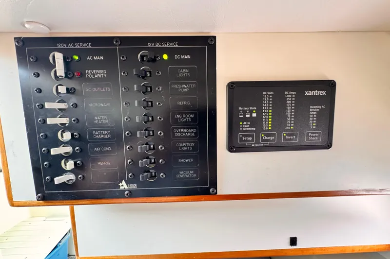 Electrical control panel on a 2003 Albin 28 TE boat, featuring AC and DC services.