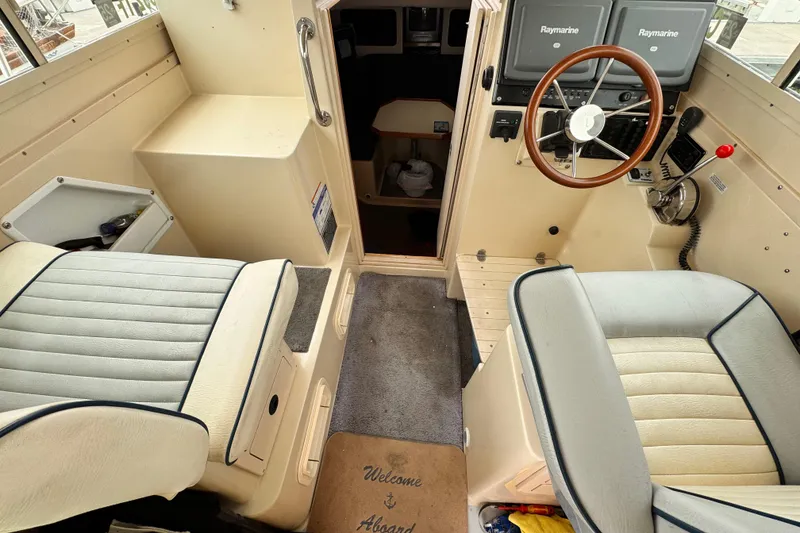 Interior of 2003 Albin 28 TE boat with steering wheel and seating.