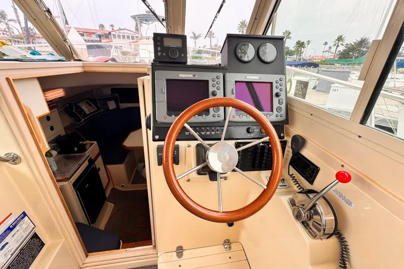 2003 Albin 28 TE boat cockpit with steering wheel and navigation equipment.