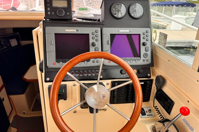 2003 Albin 28 TE boat helm with wooden steering wheel and navigation instruments.
