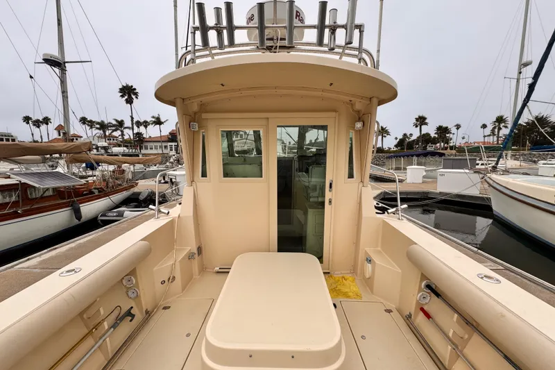 2003 Albin 28 TE boat docked at marina, showcasing spacious deck and cabin entrance.