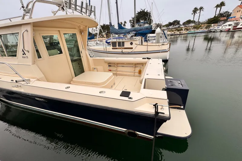 2003 Albin 28 TE boat docked in a marina, showcasing its spacious deck and cabin.