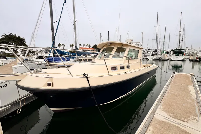 2003 Albin 28 TE boat docked in a marina, surrounded by sailboats.