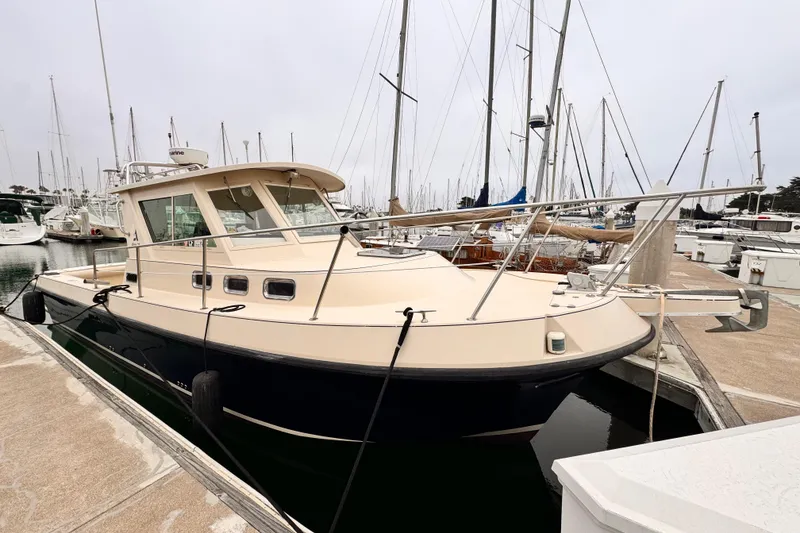 2003 Albin 28 TE boat docked at a marina with sailboats in the background.
