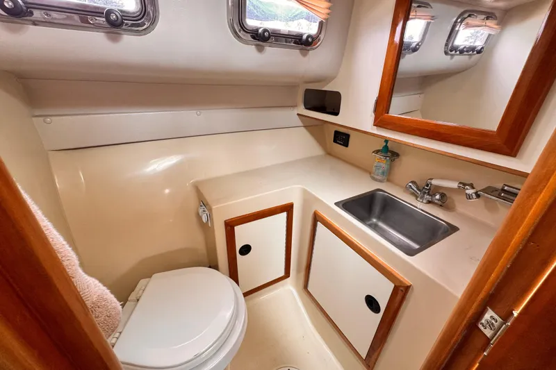 2003 Albin 28 TE boat bathroom with sink, mirror, and toilet.