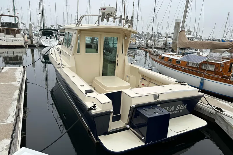 2003 Albin 28 TE boat docked in a marina, surrounded by other vessels.