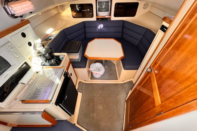 2003 Albin 28 TE cabin interior with kitchenette, seating area, and wooden finishes.