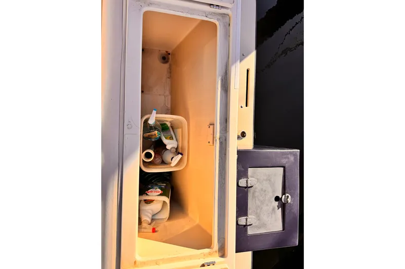 Storage compartment on a 2003 Albin 28 TE boat with cleaning supplies.