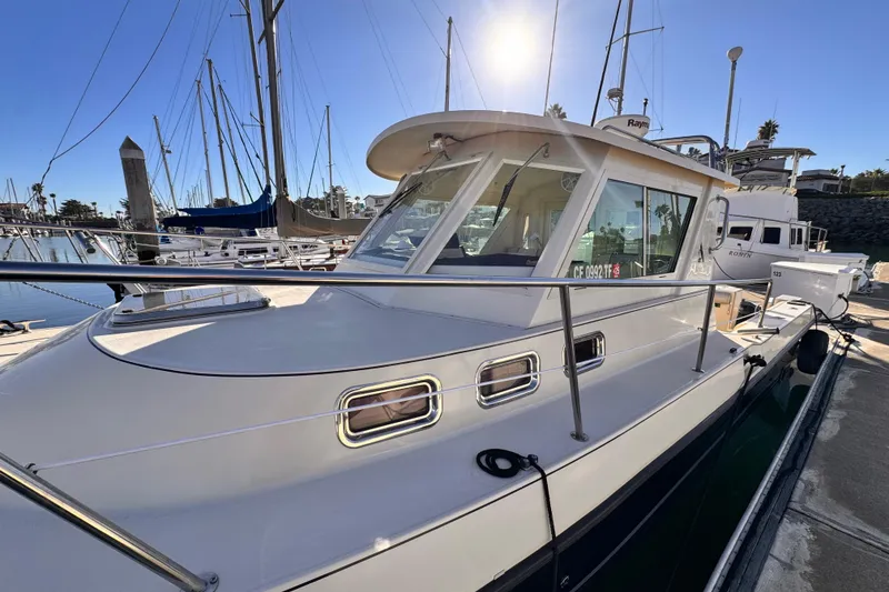 2003 Albin 28 TE boat docked in a sunny marina setting.