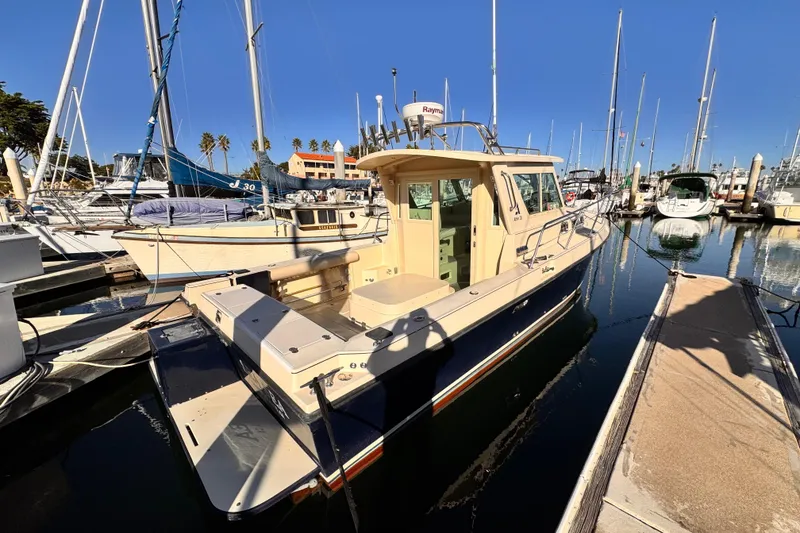 2003 Albin 28 TE boat docked in a marina under clear blue skies.