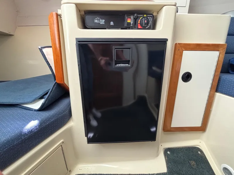 2004 Albin 28 TE interior with compact fridge and seating area.